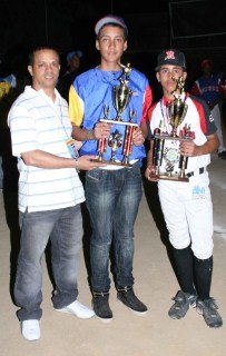 El presidente del Moca Softball Club Francisco Rodríguez entrega los trofeos al líder de ponches Jesús Rodríguez Venezuela (Aragua) y de picheo a Jaime Taveras (Moca)